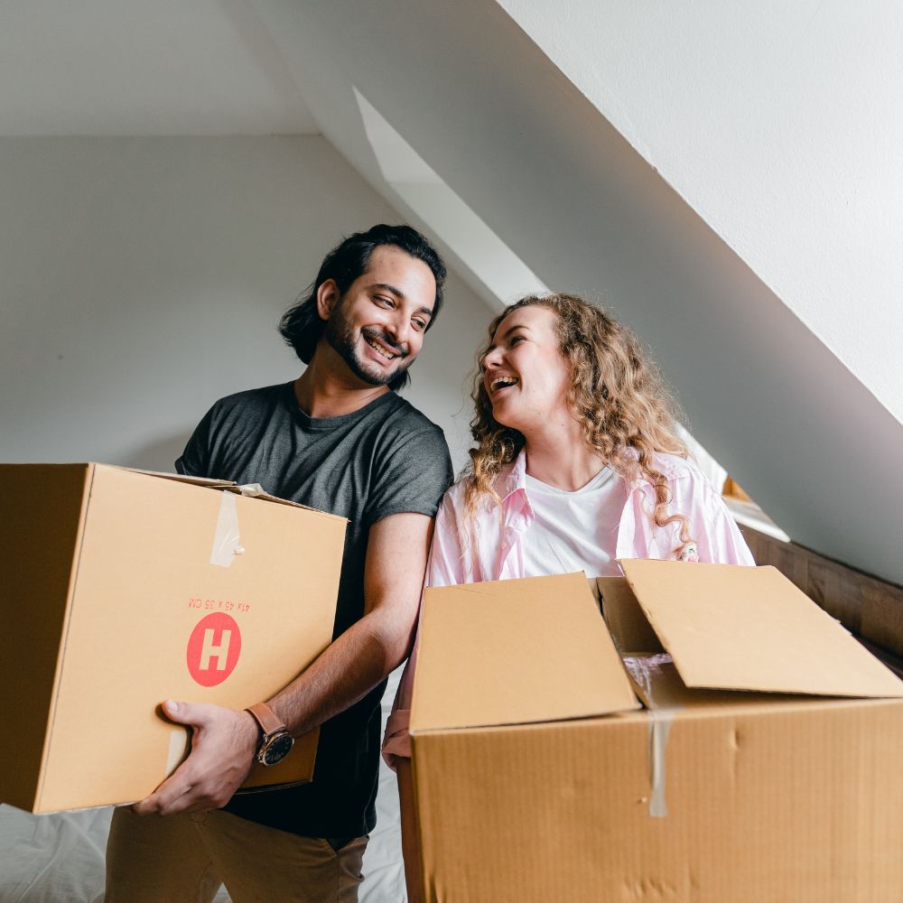 Una pareja sujetando cajas de mudanza