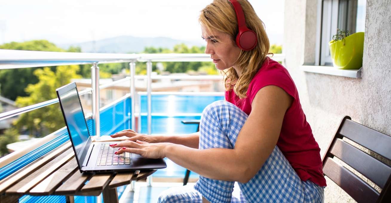 Chica teletrabajando al lado de una piscina